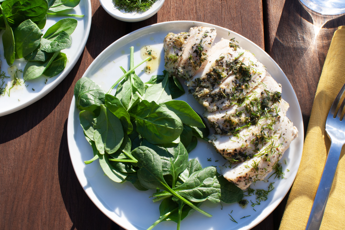 Perfectly roasted Garlic Herb Chicken Breasts served with a side of vibrant green vegetables.